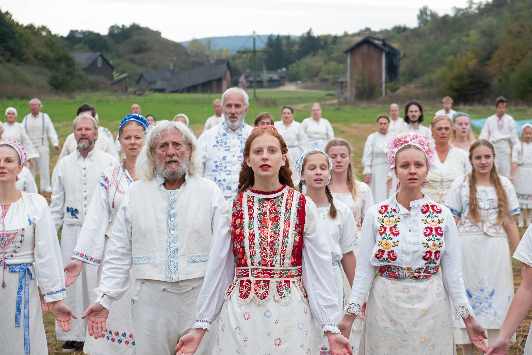 Grupp inimesi valgetes rahvariietes stseenist filmist Midsommar