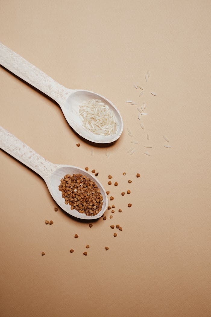 Close-up view of spoons with organic buckwheat and rice, perfect for healthy living concepts.